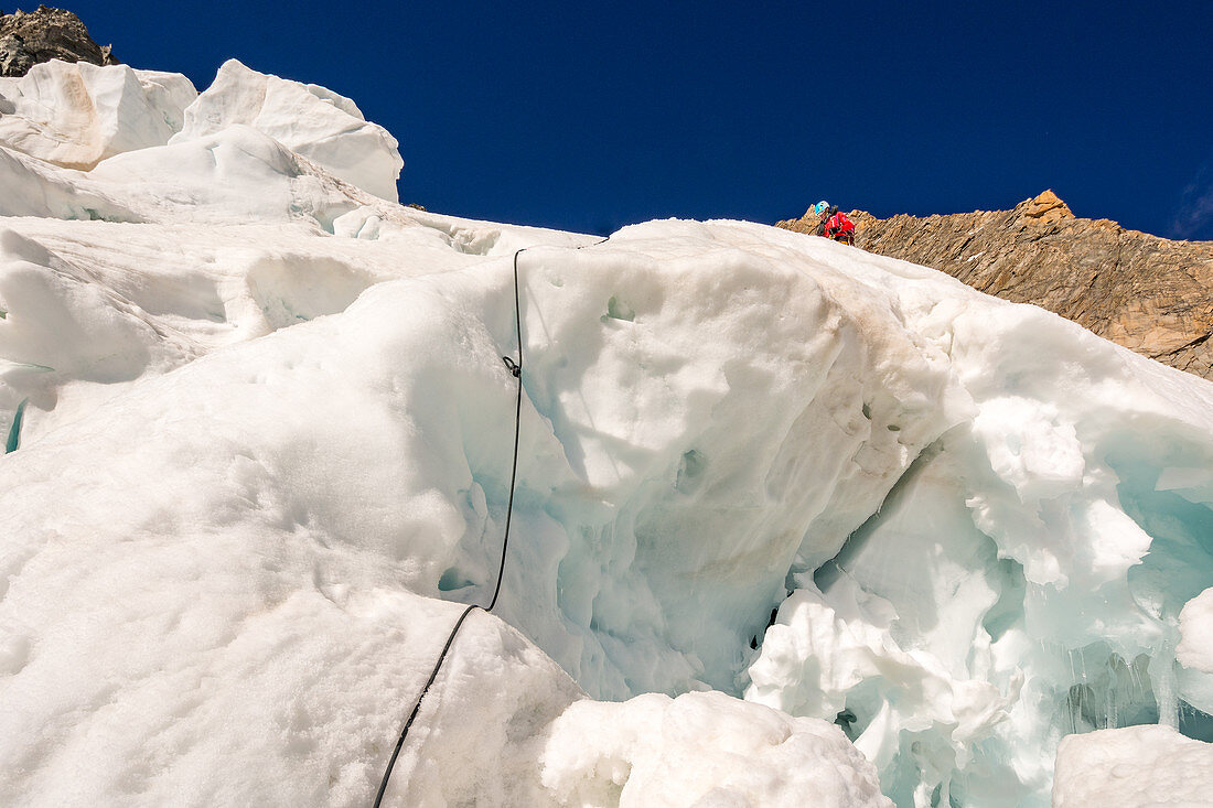 Bergsteigerin vorm Abseilen an Eisbruch, Grandes Jorasses, Mont Blanc-Gruppe, Frankreich