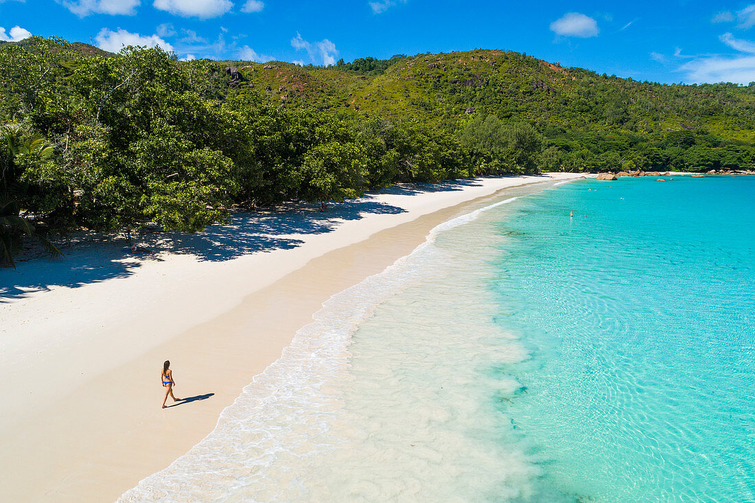 Eine Frau läuft am Strand Anse Lazio, Praslin Insel, Seychellen, Afrika