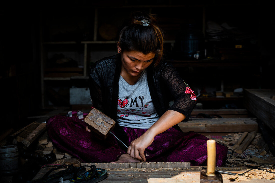 Young woman carving wood in Bhaktapur alleys, Nepal, Nepalese, Asia, Asian, Himalayan Country, Himalayas.