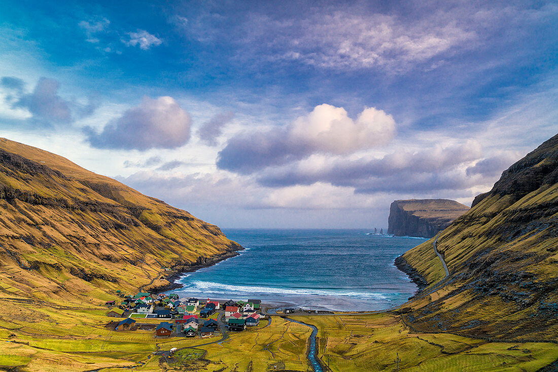 Clouds at dawn over the ocean and coastal village of Tjornuvik, Streymoy island, Faroe Islands, Denmark