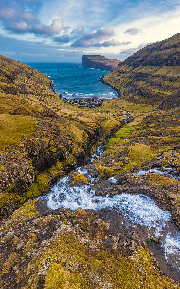 Aerial panoramic of torrent flowing toward sea, Tjornuvik, Streymoy island, Faroe Islands, Denmark