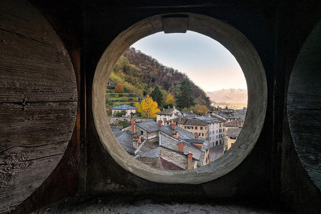 Old buildings of traditional Seriole neighborhood seen through an opening slit inside Palazzo Malacrida, Morbegno, province of Sondrio, Valtellina, Lombardy, Italy