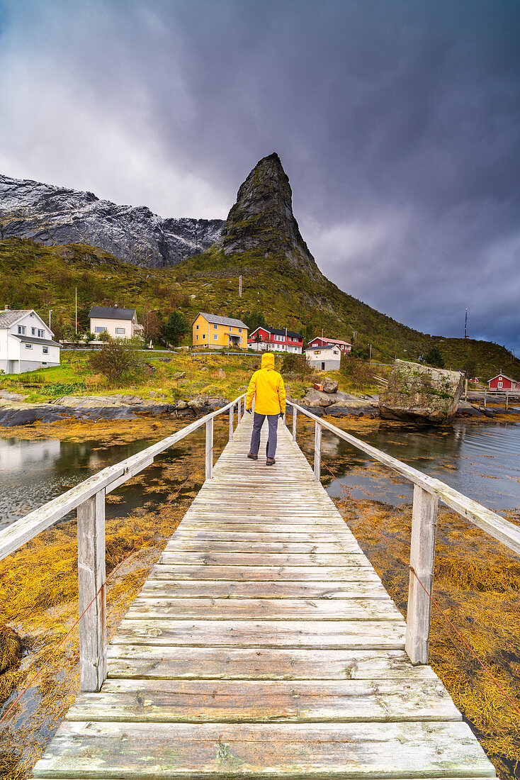 Wanderer bewundert den Hammarskaftet-Berg vom Holzweg, Reine, Nordland, Lofoten-Inseln, Norwegen