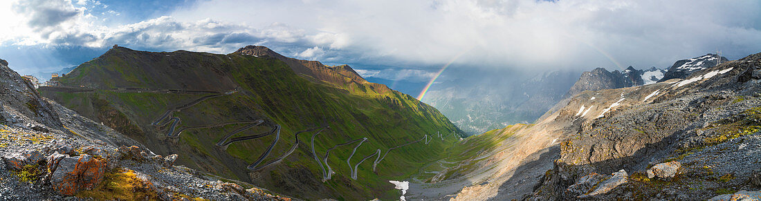 Regenbogen über den Haarnadelkurven der kurvenreichen Straße bei Stelvio Pass, Südtirol-Seite, Valtellina, Lombardei, Italien