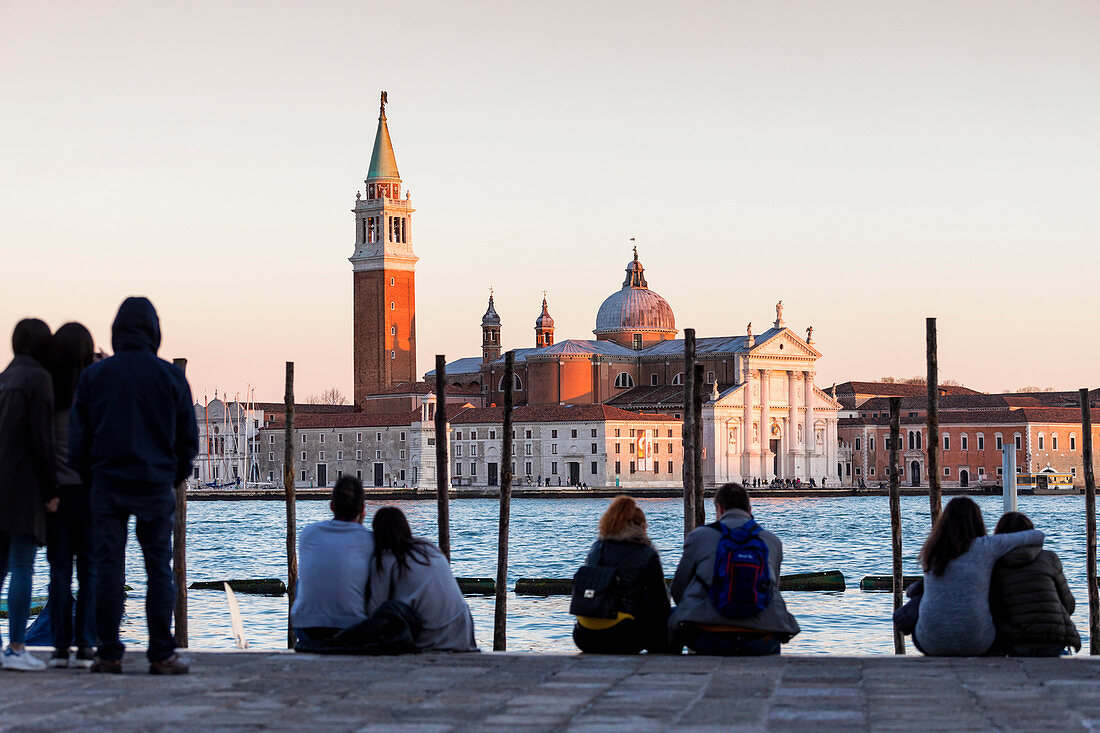 Leute auf Bank sitzend, mit Blick auf die Insel Sans Giorgio Maggiore, Venedig, Venetien, Italien, Europa