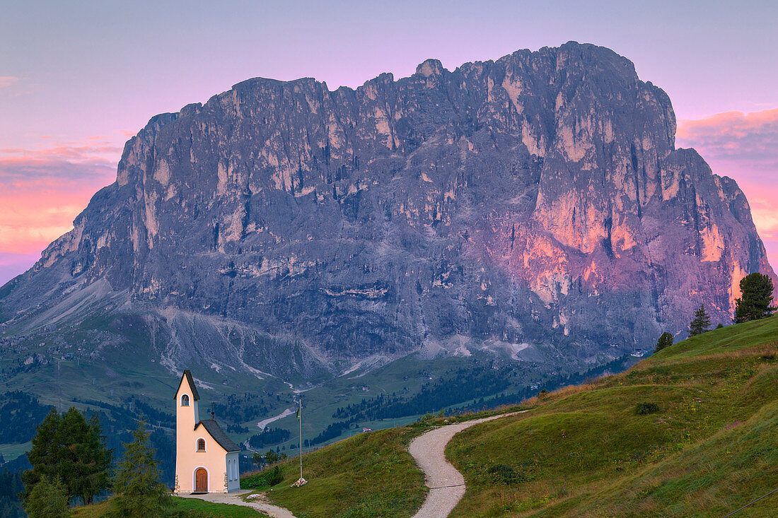 San Maurizio Chapel at sunrise with Sassolungo in the background. Gardena Pass, Gardena Valley, Dolomites, South Tyrol, Italy, Europe, Europe.