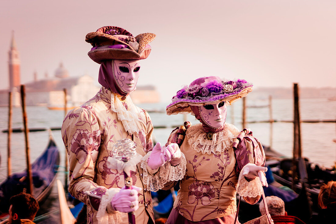 Mann und Frau im Kostüm und mit Maske beim Venedig-Karneval, Marktplatz San Marco (Markusplatz), Venedig, Venetien, Italien