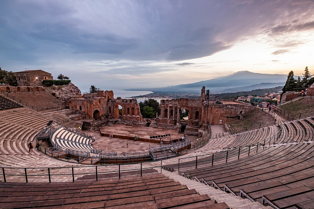 View to the Teatro di Antico of Taormina at the sunset with Etna and the Sea in the backround, Taormina, Sicily, South Italy, Italy