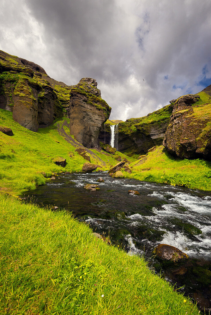 Blick auf die Felsenlandschaft am Wasserfall Kvernufoss, im Vordergrund der Fluss, Island, Europa