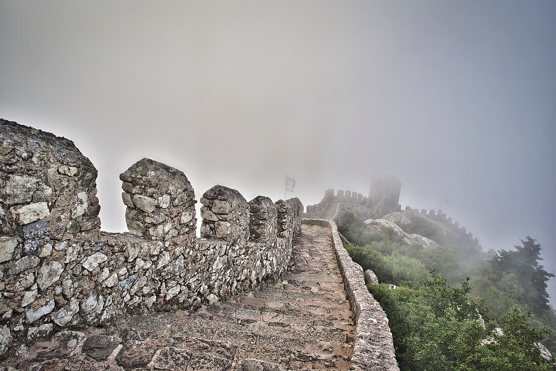 Steep stairs, wall and fortified tower in the fog in Castelo dos Mouros Sintra, Lisbon, Portugal
