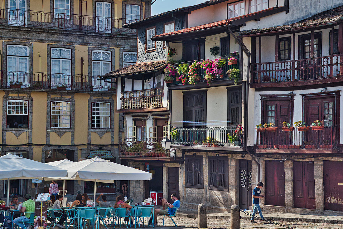 Restaurants und Menschen auf dem Platz Praca do Santiago mit typischen Häusern, Guimarães, Minho, Portugal