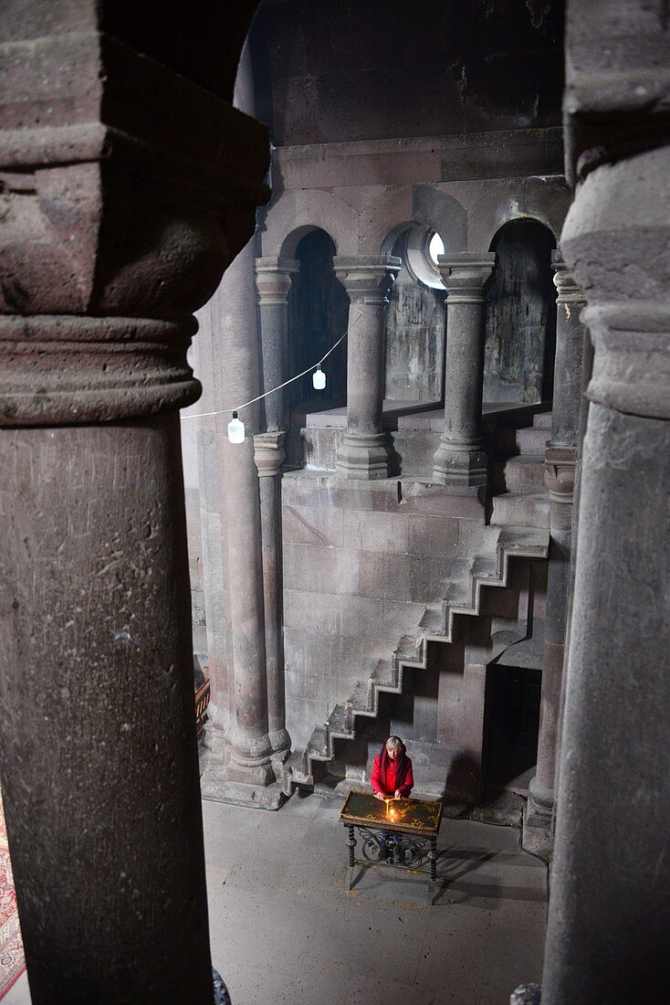 Frau mit Kerze am Opfertisch, Klosterkirche Haritchavan am Aragaz bei Gyumri, Armenien, Asien