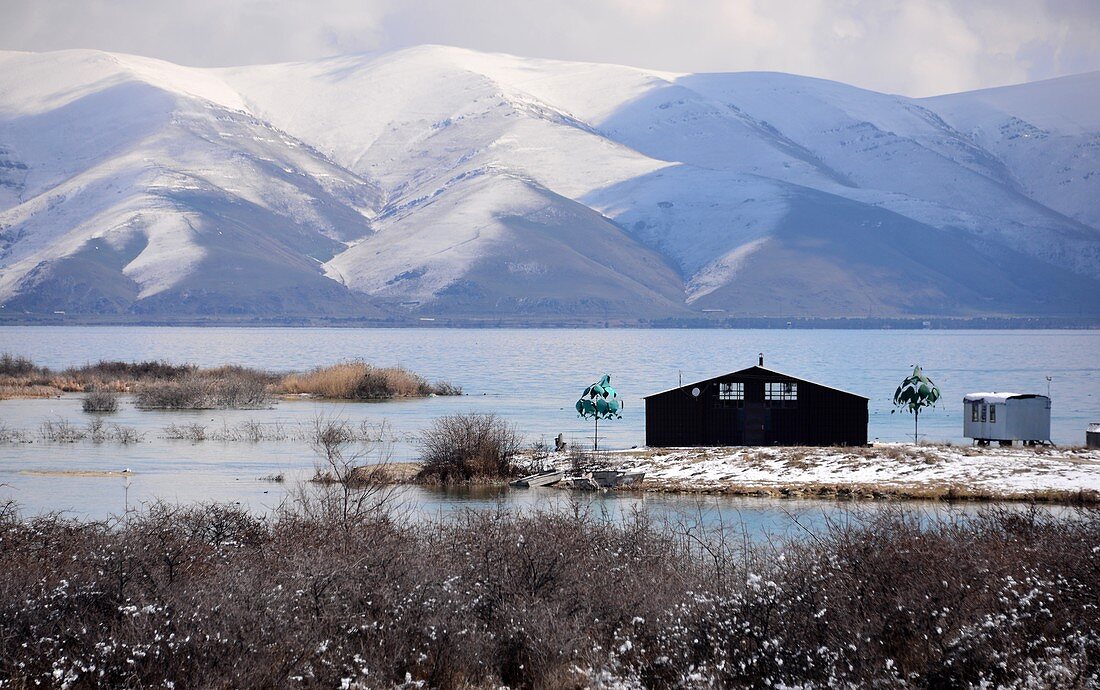 Hütte am Ufer des Sees, Blick mit schneebedeckten Bergen, Sewansee, Armenien, Asien