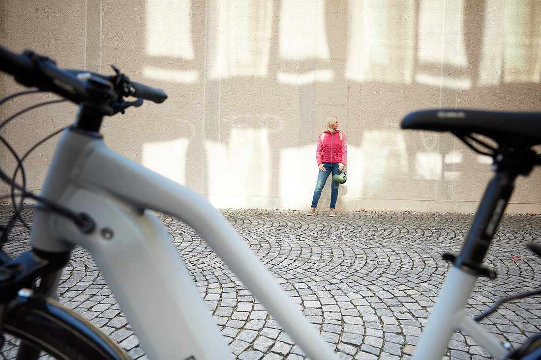 Junge Frau auf Fahrrad in urbaner Umgebung, München, Bayern, Deutschland