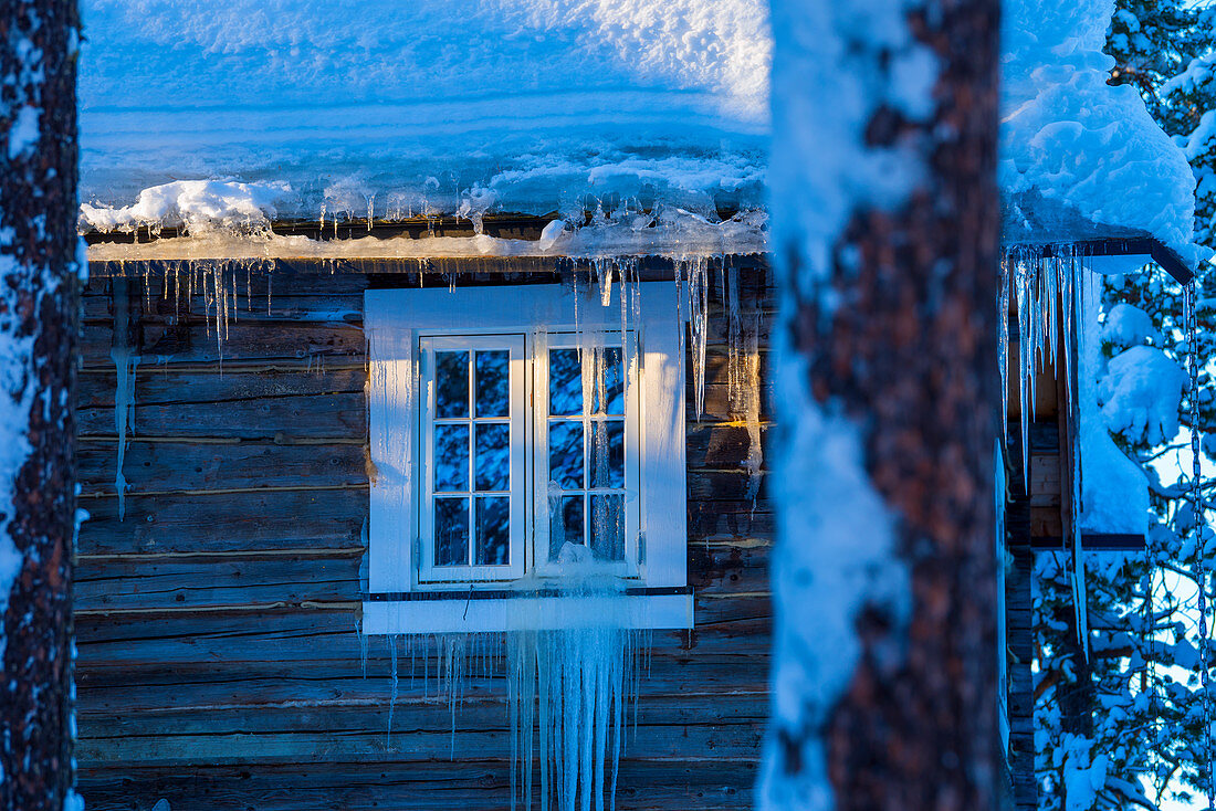 Fenster eines Holzhauses bei Heggenes im Winter, Norwegen