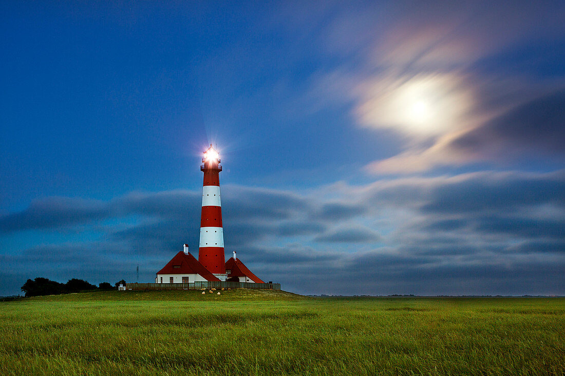 Full moon breaks through the clouds at the lighthouse Westerhever, North Sea, Schleswig-Holstein, Germany