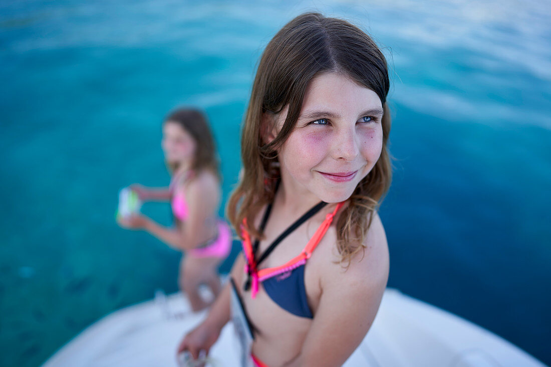 2 girls on the bathing platform of a sailing yacht, Bay of Tomozina, Cres, Croatia