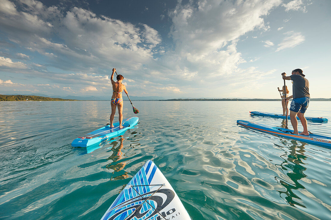 Junge Leute beim Stand Up Paddling auf dem Starnberger See, Bayern, Deutschland