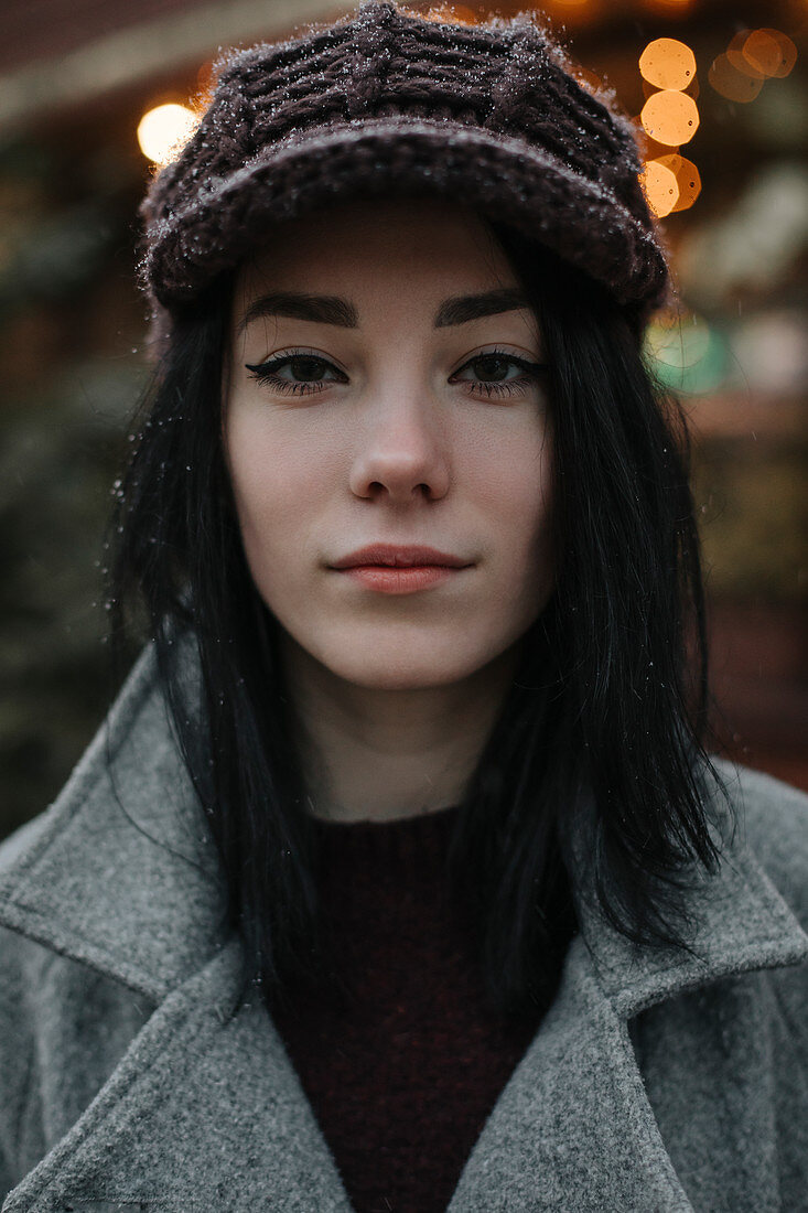 Portrait of young woman wearing woolly hat and eyeliner