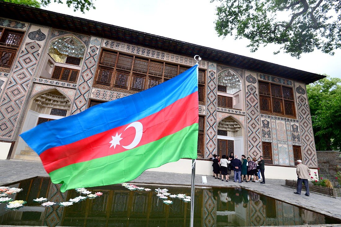 Flag of Azerbaijan and facade of the historic Xan Sarayi Fortress in Sheki, Azerbaijan, Asia