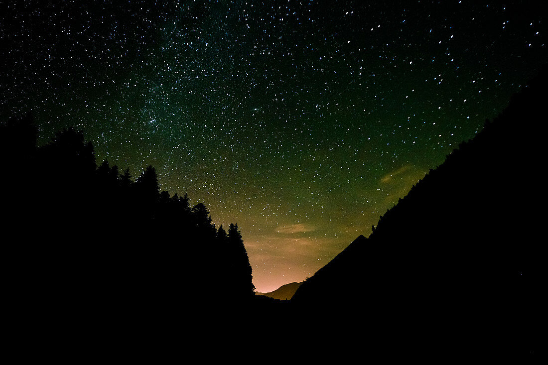 Mountain and forest silhouettes in front of the starry sky. Obersee. Switzerland