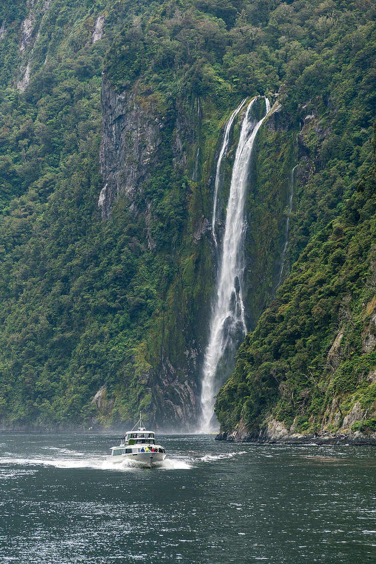 Touristisches Boot und Stirling Falls in Milford Sound. Fiordland NP, Southland Bezirk, Southland Region, Südinsel, Neuseeland