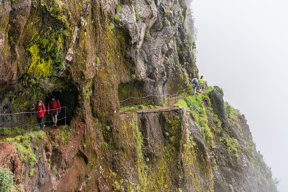 People walking on the trail from Pico Ruivo to Pico do Areeiro. Santana, Madeira region, Portugal.