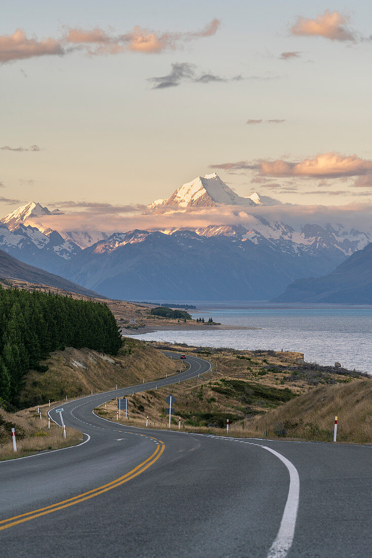 Straße neben See Pukaki bei Sonnenuntergang, blickend in Richtung Mt-Kochgebirgszug. Ben Ohau, Mackenzie-Bezirk, Canterbury-Region, Südinsel, Neuseeland