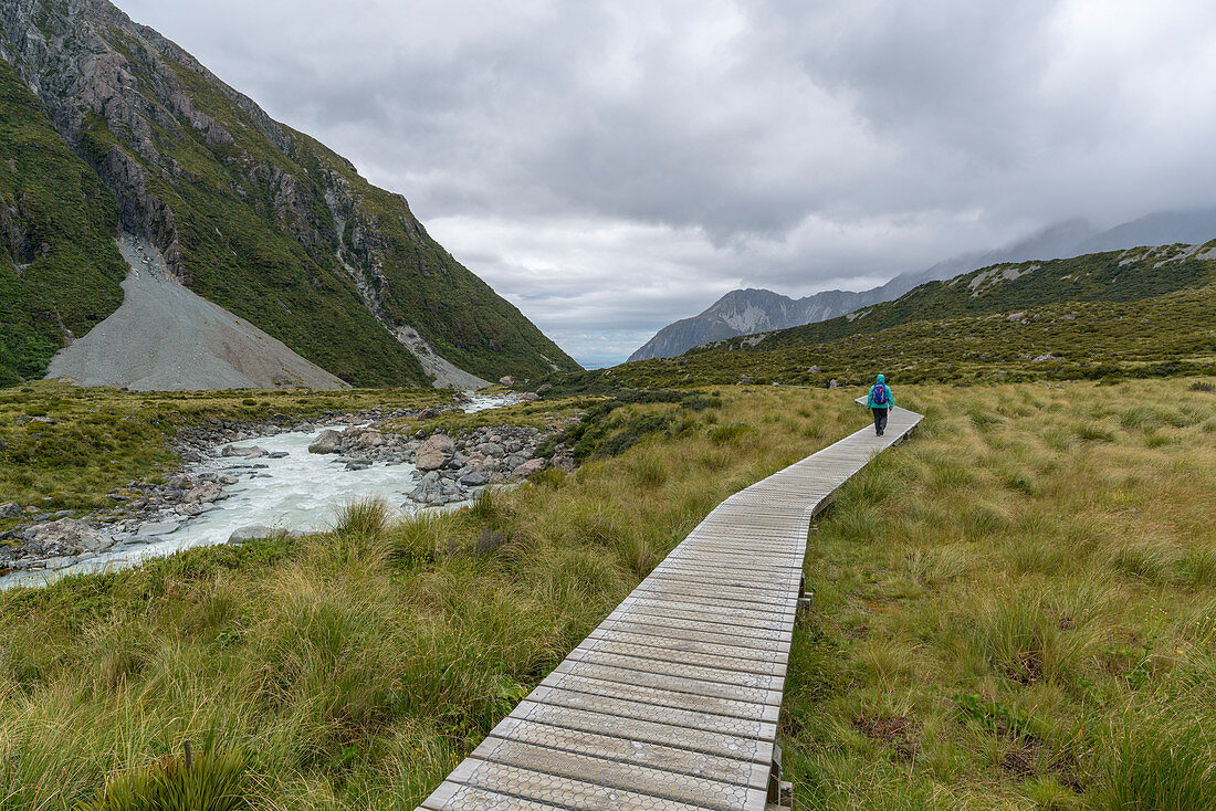 Hiker walking on Hooker Valley Track. Mount Cook National Park, Mackenzie district, Canterbury region, South Island, New Zealand.