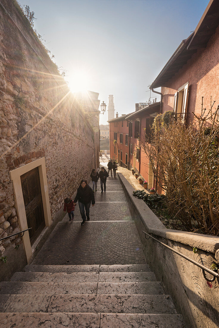 Verona, Venetien, Italien. Leute, die auf eine alte Straße von Verona gehen