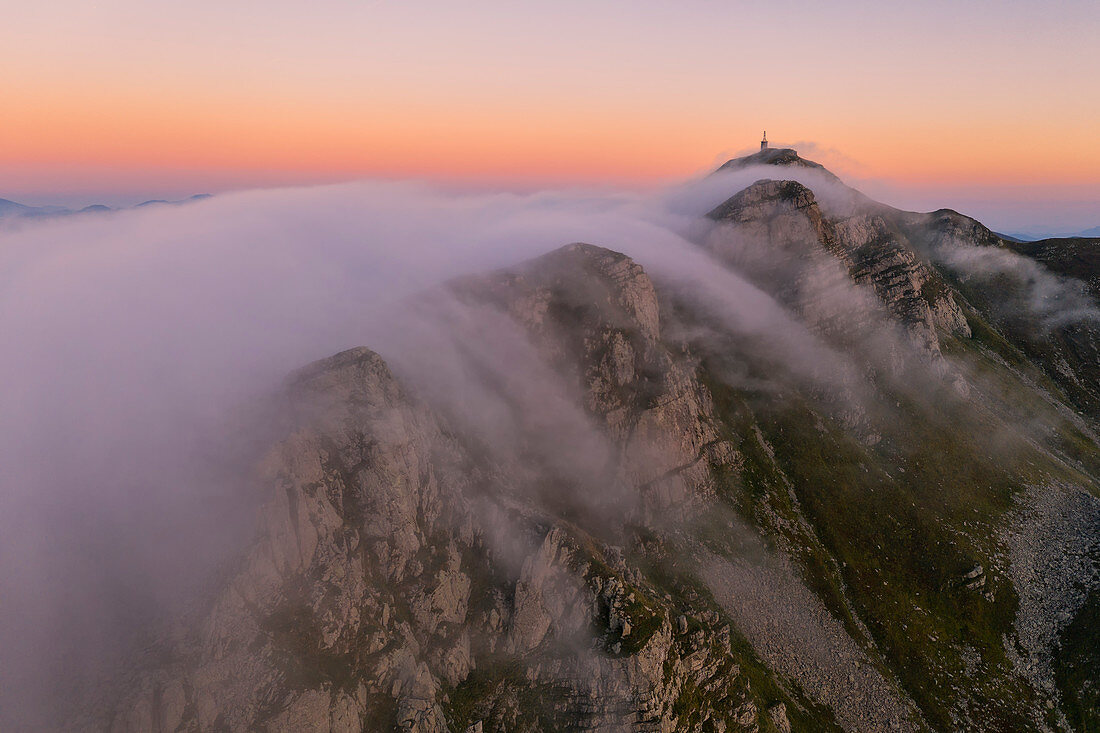 Luftaufnahme von La Nuda Mountain bei Sonnenuntergang mit Nebel, Cerreto Laghi, Gemeinde Ventasso, Provinz Reggio Emilia, Emilia Romagna Distrikt, Italien, Europa