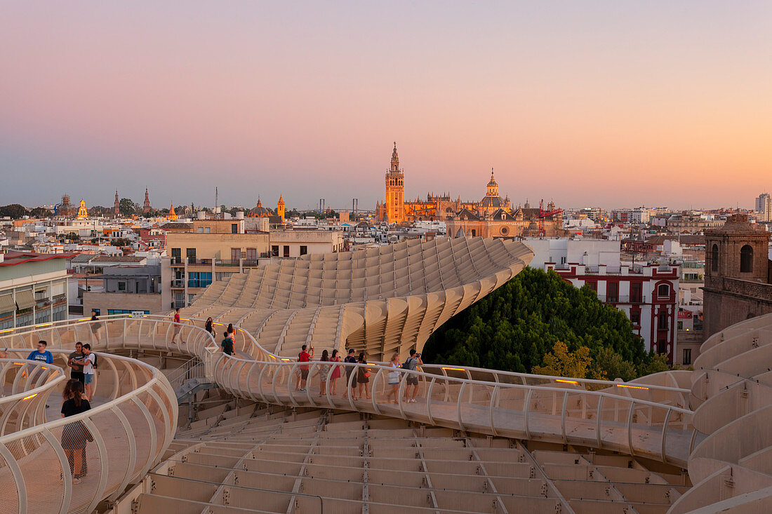 Tourists on the curved footbridge of Metropol Parasol at sunset, Seville, province of Seville, Andalusia, Spain