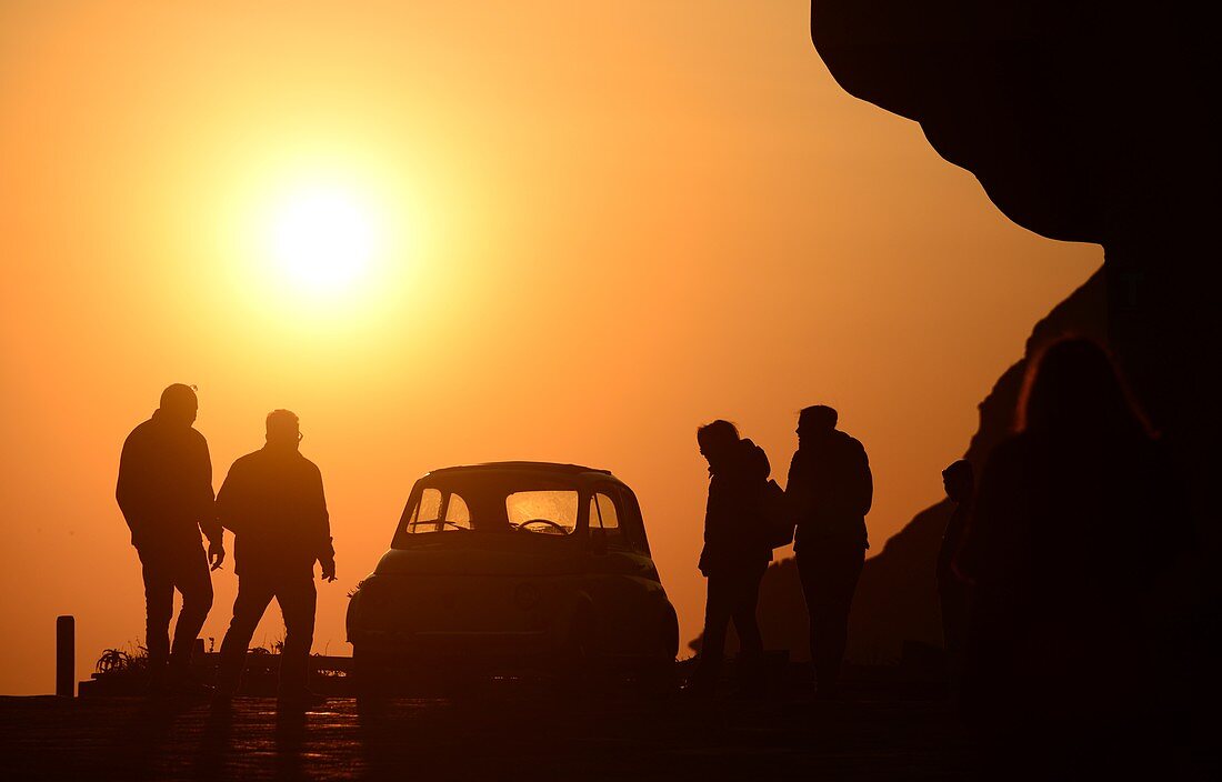 Sonnenuntergang mit Fiat 500 und 4 Personen bei Sant Angelo, Insel Ischia, Kampanien, Italien