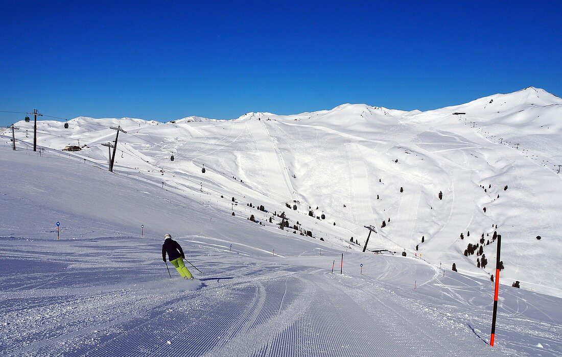 A skier on a ski slope in the Wildkogel im Pinzgau ski resort, winter in Salzburger Land, Austria