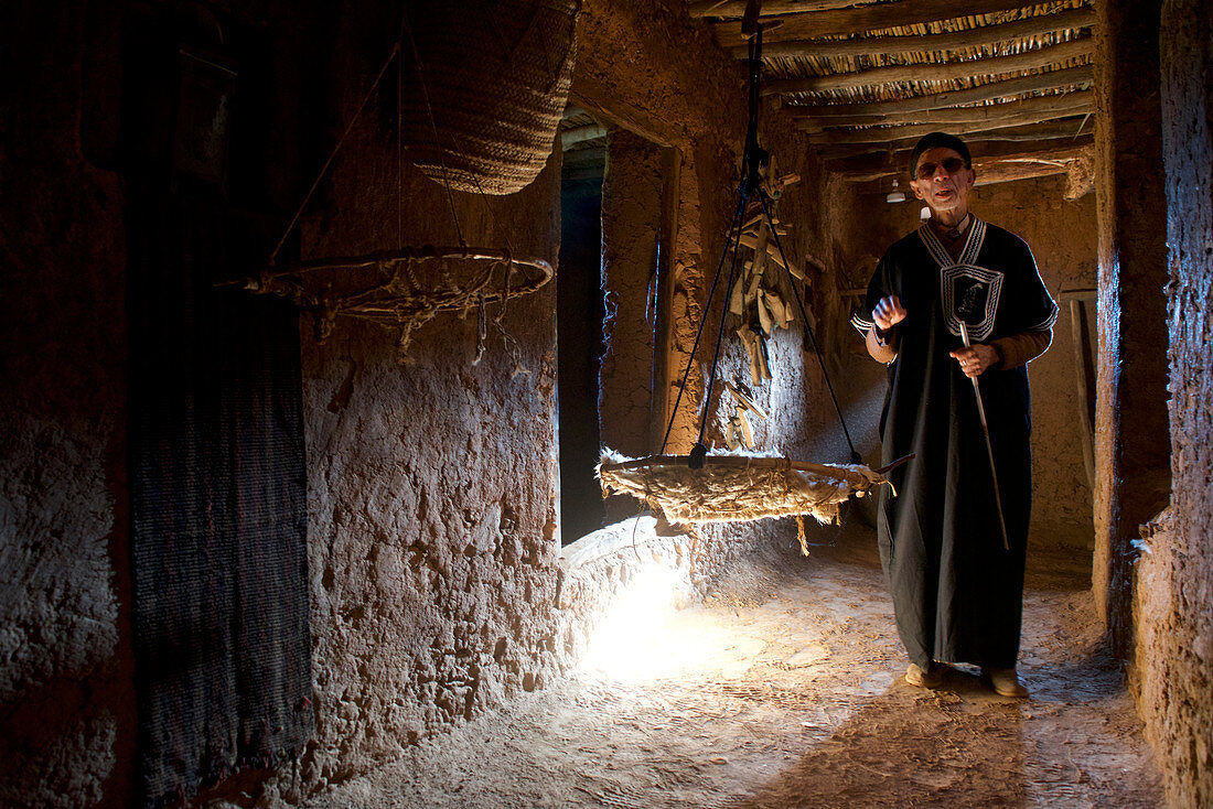 Alter blinder Mann, Berber, führt durch ein traditionelles Berberhaus, Tal der Ammeln im Antiatlas, Marokko