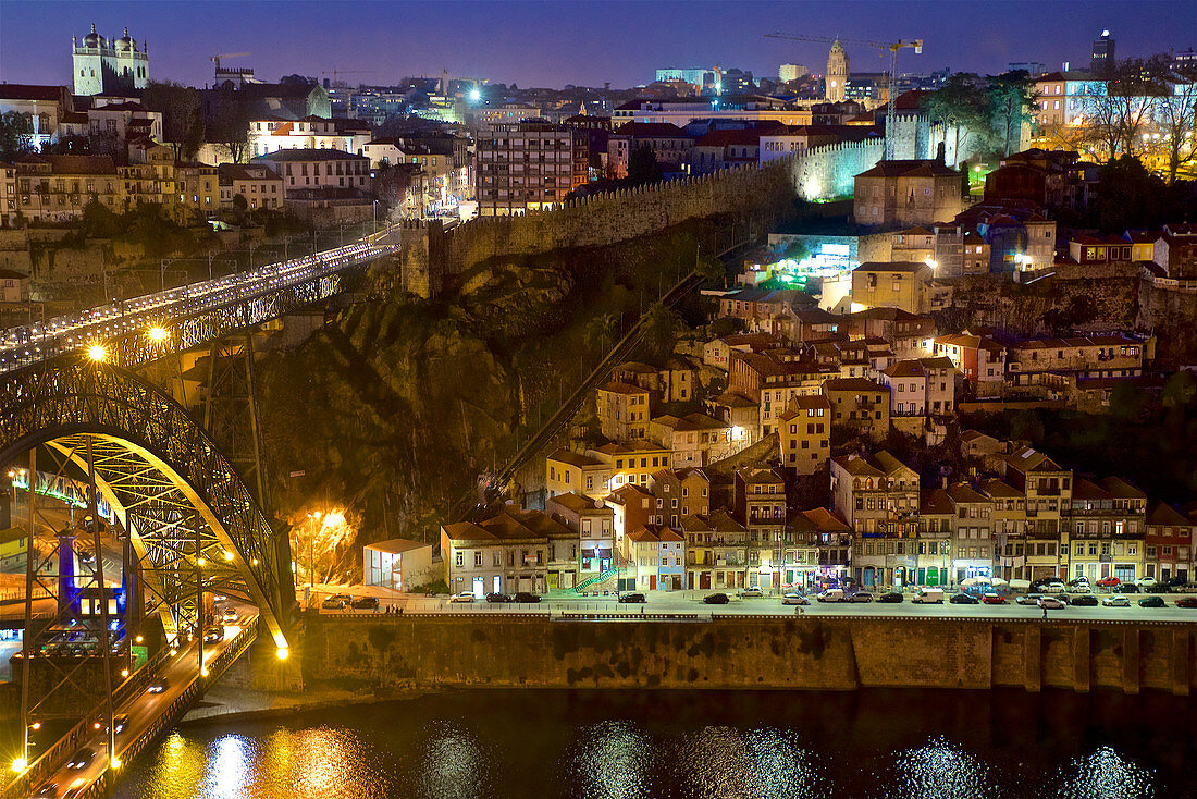 Blick über die Ponte Dom Luis I. zum  Cais da Ribeira mit verschachtelten Häusern am steilen Hang und der Festungsmauer, Porto, Portugal