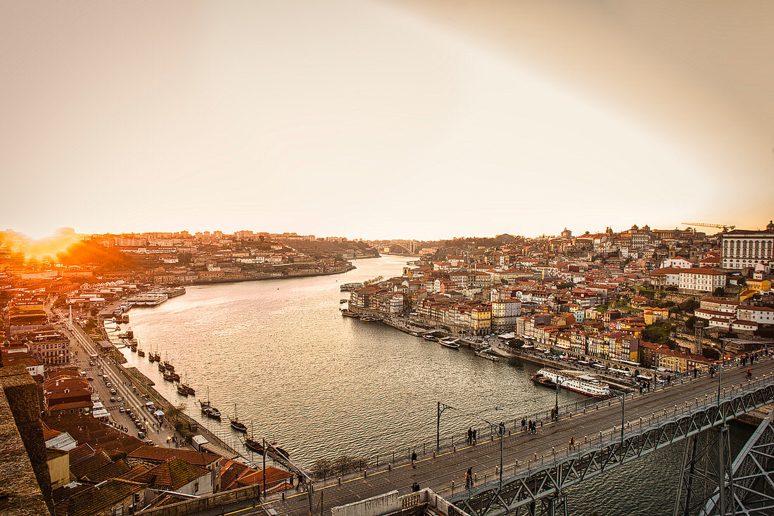 Blick bei Sonnenuntergang über die Ponte Dom Luis I. und über den Douro mit Vila Nova de Gaia und dem Cais da Ribeira, Porto, Portugal