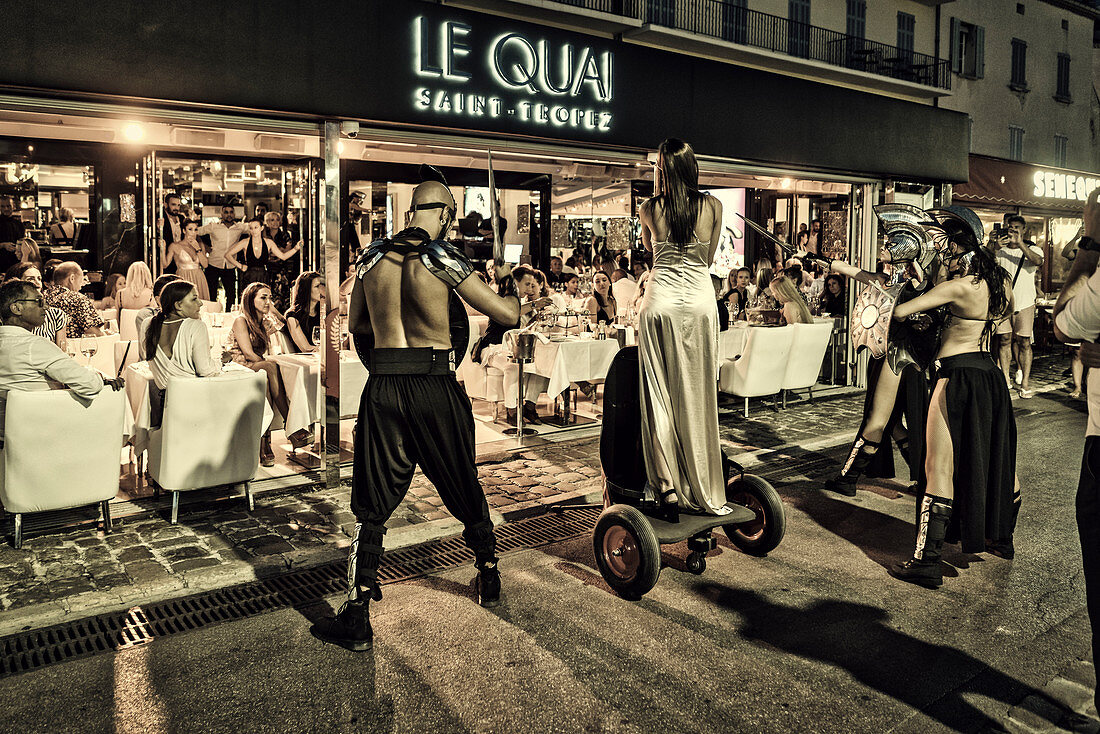 Dance group in front of the trendy Le Quai amn harbor of St. Tropez, Var, Cote d'Azur, South of France, France, Europe, Mediterranean Sea, Europe