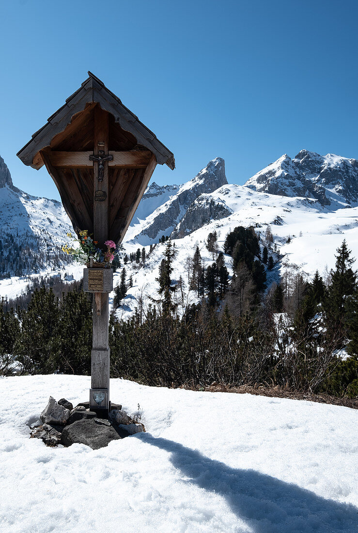 Holzkreuz vor dem Bergpanorama der Dolomiten im Winter, Dolomiten, Belluno, Italien