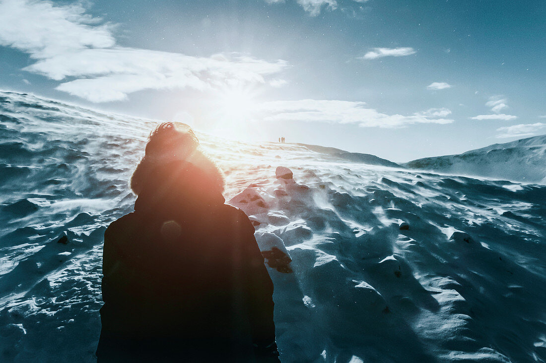 Teenager in schneebedecktem Berg, Reykjadalur, Island