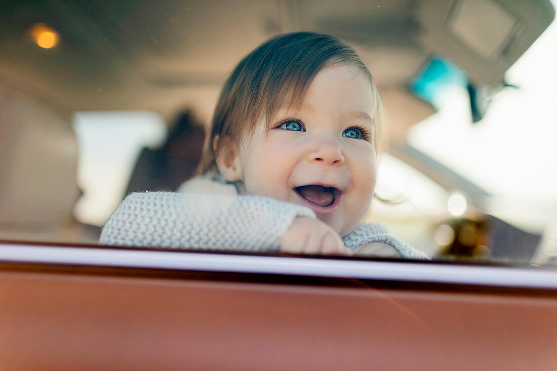 Lächelndes Baby hinter Autofenster
