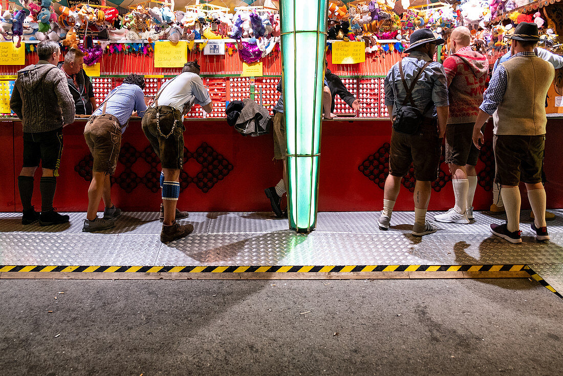 Men in Bavarian costume at the shooting range at the Oktoberfest, Munich, Bavaria, Germany