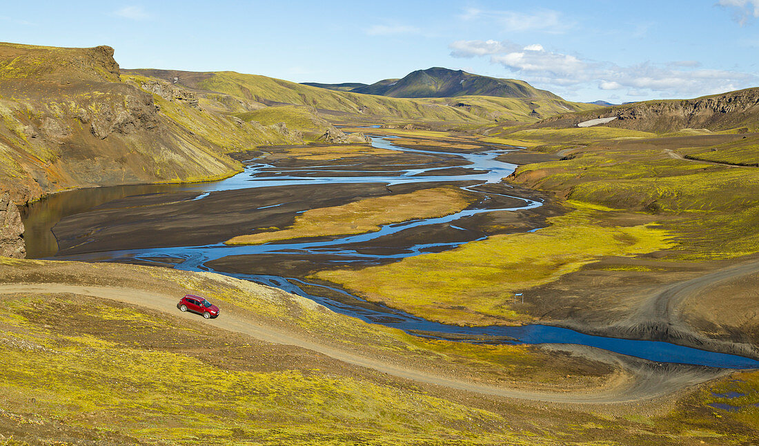 Auto im breiten Tal mit Fluss, Island