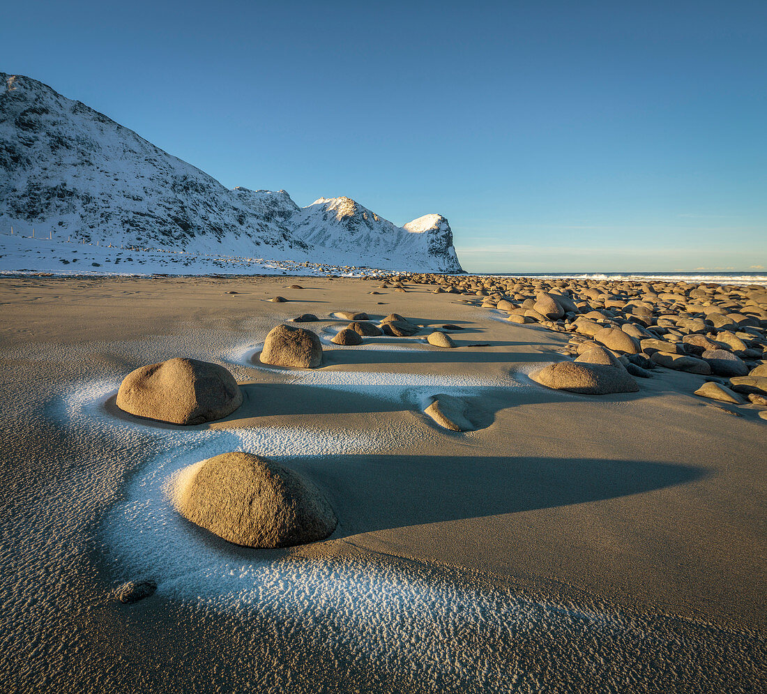 Strand mit Flusssteinen im Winter, Norwegen