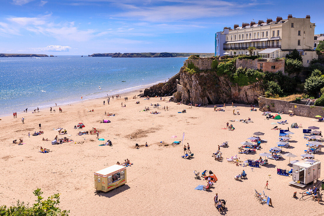 Castle Beach, historic houses above the cliffs, sunbathers on a sunny day in summer, Tenby, Pembrokeshire, Wales, United Kingdom, Europe