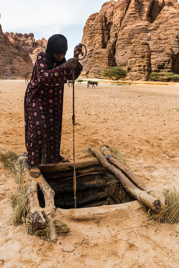 Bedouins pulling water in a beautiful rock amphitheatre in the Ennedi plateau, UNESCO World Heritage Site, Chad, Africa