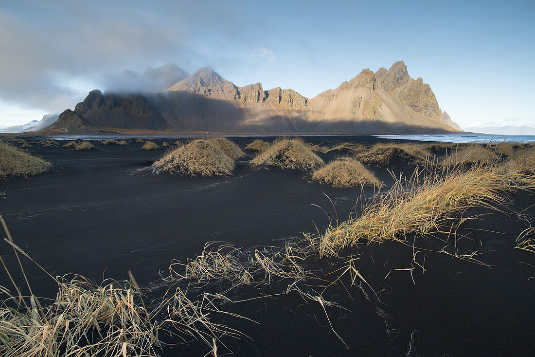 Schwarzer sandiger Strand mit dem Vestrahorn-Berg im Hintergrund, Island