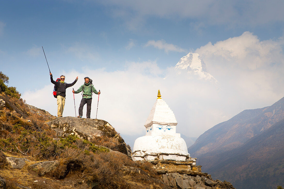 Zwei glückliche Wanderer nahe einem buddhistischen Stupa und mit Ama Dablam-Berg im Hintergrund, Weg zum Everest Base Camp (EBC)