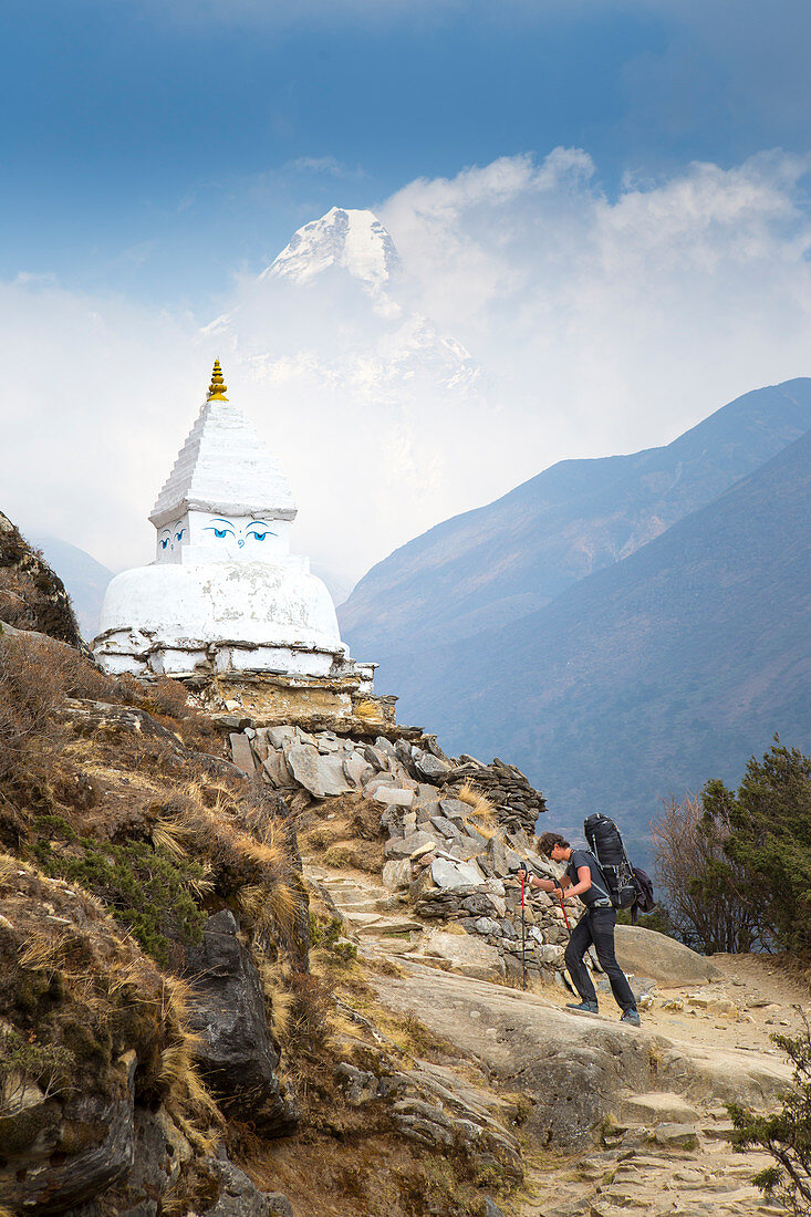 A hiker near a Buddhist Stupa with the eyes of Buddha painted. In the background the mountain Ama Dablam. The trek to Everest Base Camp (EBC) is possibly the most dramatic and picturesque in the Nepalese Himalaya. Not only will you stand face to face with Mount Everest, Sagarmatha in Nepali language, at 8,848 m (29,029 ft), but you will be following in the footsteps of great mountaineers like Edmund Hillary and Tenzing Norgay. The trek is scenic and offers ever-changing Himalayan scenery through forests, hills and quaint villages. A great sense of anticipation builds as you trek up the Khumbu 