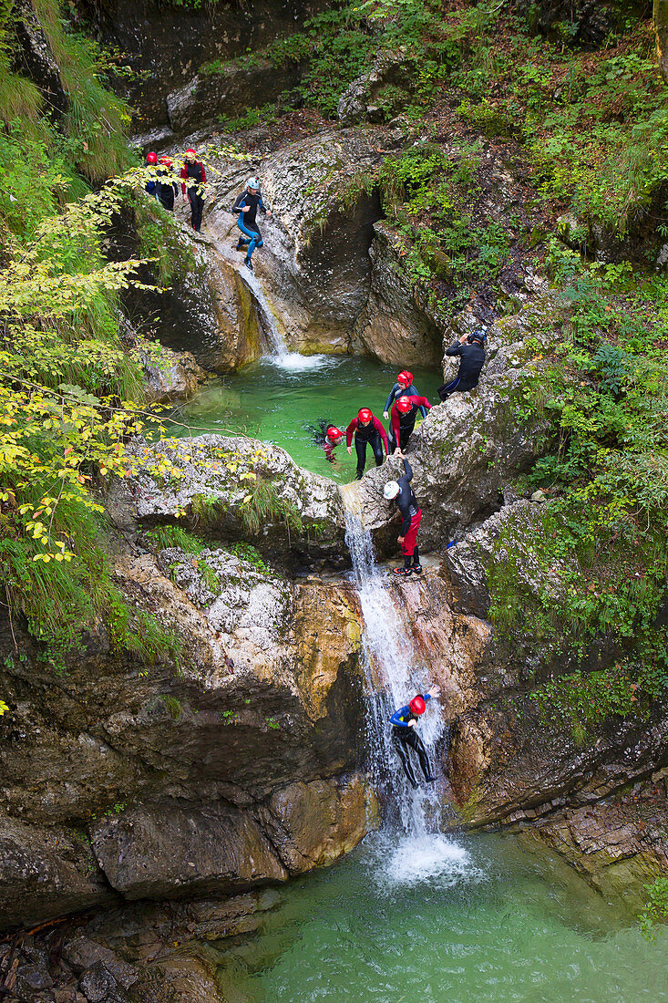 Canyoning in einer engen Schlucht mit Stromschnellen, Pools und Wasserfällen im Soca-Tal in der Nähe von Bovec, Slowenien.